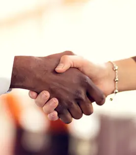 Handschlag durch einen dunkel- und einen hellhäutigen Menschen